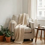 Coin salon cosy avec fauteuil en lin et plantes en pot dans un appartement au style scandinave épuré
